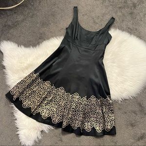 Black satin midi dress with gold trim detail at hem